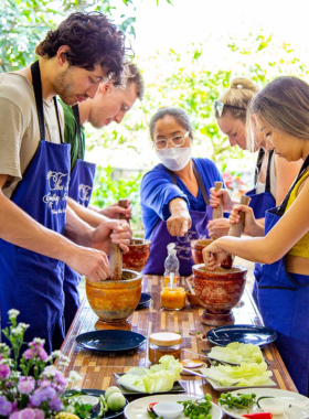 This image shows participants learning to cook traditional Thai dishes in a hands-on cooking class. The experience includes visits to local markets for fresh ingredients and the chance to master Northern Thai cuisine, offering an immersive journey into the country’s rich culinary traditions.