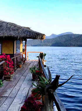 This image shows the serene beauty of Si Lanna National Park, with visitors kayaking on the calm waters of the lake, surrounded by verdant forests, and exploring the tranquil natural environment.