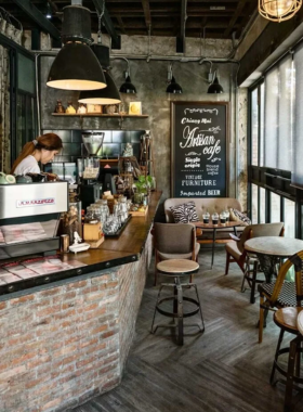 This image shows a modern, minimalist coffee shop interior at Graph Café in Chiang Mai. A cup of cold brew and a slice of avocado toast is served on a clean wooden table, reflecting the café’s chic and relaxing vibe.