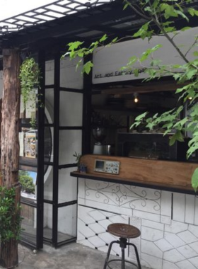 This image shows a serene hilltop café with a cup of cappuccino on an outdoor table at SS1254372 Café in Chiang Mai. The café’s panoramic views and relaxing vibe offer a unique coffee experience.