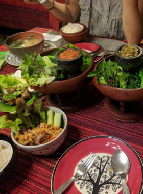 This image shows a bowl of Gaeng Hang Lay, a traditional Northern pork curry served with sticky rice at Huen Phen restaurant in Chiang Mai. The homely setting complements the authentic flavors of this classic Thai dish.