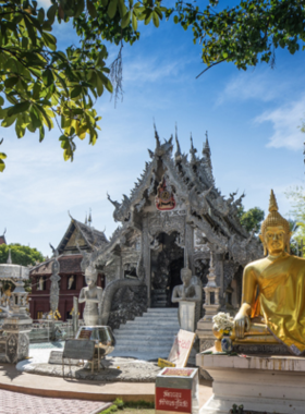 This image shows the stunning Silver Temple at Wat Sri Suphan, with its reflective metallic structure shining under the sunlight. The intricate engravings on the temple walls depict Buddhist teachings and cultural motifs. The temple’s unique silver design stands out, making it a masterpiece of craftsmanship. Visitors admire the artistry and spiritual ambiance surrounding this cultural and religious gem.