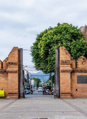 This image shows the iconic Thapae Gate, a historical landmark in Chiang Mai, beautifully captured during sunrise or sunset, showcasing the intricate details of the ancient brick structure.