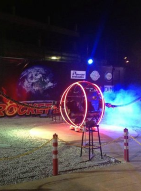 This image shows the thrilling SKY Pattaya Rocket Ball Ride, where riders are launched high into the air, providing an exciting view of the Pattaya coastline. The sky is clear, and the adrenaline rush from the ride can be seen on the faces of the excited riders, who are lifted high above the ground.