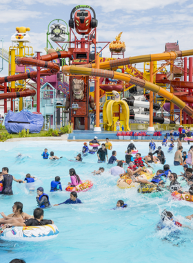 This image shows children and families enjoying the thrilling water rides at Cartoon Network Amazone Water Park in Pattaya. The park features various themed water attractions based on popular cartoon characters. Visitors are seen laughing and having fun as they slide down exciting water slides and splash in the pools.