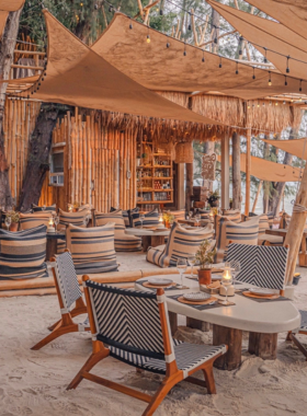 This image shows the stunning beachfront setting of The Glass House in Pattaya, featuring elegant glass-walled architecture and a serene dining area surrounded by nature. Guests can enjoy fresh seafood and other dishes while admiring the tranquil sea view.