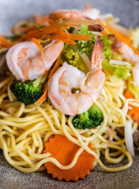 This image shows Mama’s Noodles street food cart in Pattaya, with steaming bowls of spicy tom yum noodle soup. Locals and tourists are savoring the authentic Thai flavors at an affordable price.