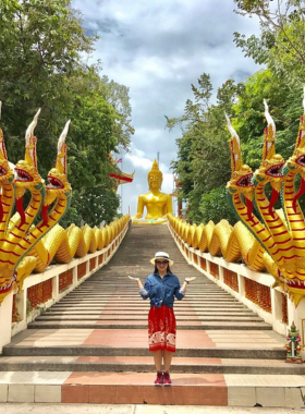 This image shows the golden Buddha statue at Wat Phra Yai, standing tall amidst lush gardens. The panoramic view of Pattaya from the hilltop adds to the spiritual and scenic charm of the place.