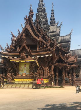 This image shows the intricate wooden carvings of The Sanctuary of Truth, set against a peaceful natural background. The craftsmanship and serene surroundings combine spirituality and architectural beauty.