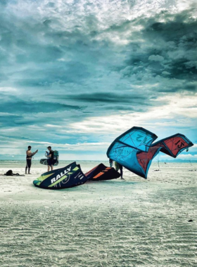 This image shows an exhilarating kitesurfing session in Koh Samui, with a kite soaring high above the turquoise waters, showcasing the thrilling water sport that attracts adventure seekers to the island’s shores.