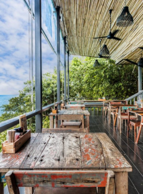 This image shows Vikasa Life Cafe overlooking the ocean in Koh Samui, with a serene setting for enjoying healthy vegan and vegetarian meals. It highlights the beautiful ocean backdrop, clean and minimal decor, and delicious smoothie bowls served in the cafe.