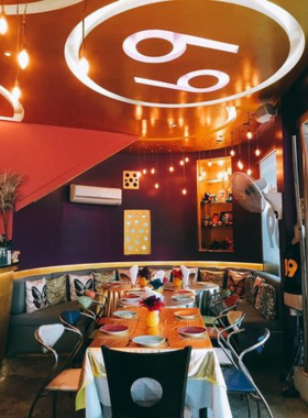 This image shows Cafe 69 in Koh Samui, with its vibrant and quirky interior design. It highlights the fusion of Thai and international cuisine, showcasing creative dishes like green curry spaghetti and duck spring rolls, served in a cheerful atmosphere.