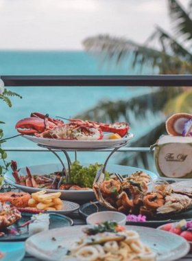 This image shows The Cliff Bar & Grill in Koh Samui, set on a stunning cliffside with sweeping sea views. It highlights the restaurant’s elegant dining area, Mediterranean-inspired dishes, and the serene, romantic ambiance perfect for a leisurely meal.