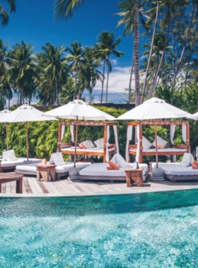 This image shows Nikki Beach in Koh Samui, a luxurious beach club featuring vibrant parties, a poolside lounge, and stunning ocean views ideal for both relaxation and lively entertainment.