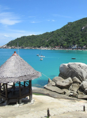 This image shows the tranquil and secluded Haad Yuan Beach, also known as Secret Beach, in Koh Samui. The beach, surrounded by lush hills, is perfect for those looking for a quiet spot to relax, swim, and enjoy the peaceful surroundings away from crowded tourist areas.