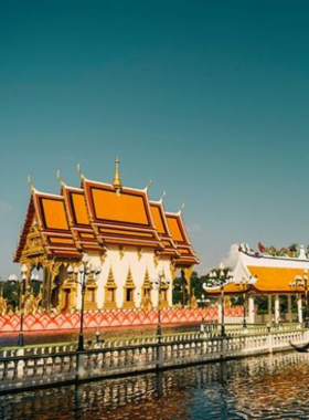 This image shows the colorful Wat Plai Laem temple, featuring the intricate statue of Kuan Yin surrounded by a tranquil pond filled with koi fish, blending spiritual and natural beauty.