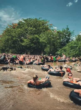 This image shows visitors enjoying tubing in Pai's tranquil river, floating downstream on rubber tubes. The scenic surroundings of lush greenery, mountains, and clear skies make the experience even more relaxing. Tubing is a popular activity for travelers looking to unwind and connect with nature, offering a fun and refreshing way to explore Pai’s natural beauty.