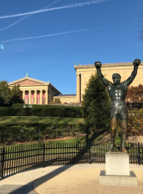 This image shows visitors climbing the famous Rocky Steps at the Philadelphia Museum of Art. Known from the "Rocky" movie, the steps offer an inspiring view of the city and are a must-see for both fitness enthusiasts and movie fans.