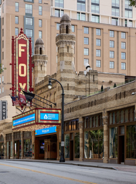 This image shows the historic Fox Theatre in Atlanta, lit up with its iconic marquee lights. The ornate architectural details are visible, reflecting its rich history and reputation as a premier entertainment venue.