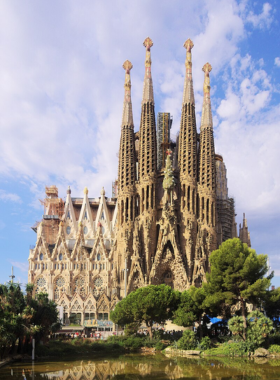 This image shows the intricate and towering facades of La Sagrada Família, Antoni Gaudí's architectural masterpiece in Barcelona. The image captures the detailed design and vibrant stained glass windows that make the church a UNESCO World Heritage Site, attracting millions of visitors every year.