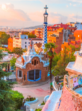 This image shows the bustling Las Ramblas, the most famous street in Barcelona, lined with trees, cafes, and street performers. The vibrant atmosphere makes it a popular spot for both locals and tourists to enjoy the city's lively energy.