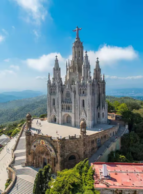 This image shows the stunning view from Tibidabo Hill in Barcelona, featuring the iconic Sagrat Cor Church and vintage amusement park. Visitors can enjoy breathtaking cityscapes and a fun day out with family and friends.