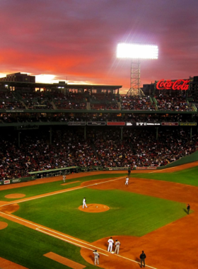 This image shows Fenway Park, home to the Boston Red Sox, with its iconic Green Monster wall and a stadium full of enthusiastic fans. It captures the vibrant energy of a live baseball game and the historic charm of one of America’s oldest ballparks.