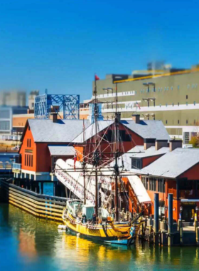 This image shows the Boston Tea Party Museum, with replica ships docked along the waterfront. Visitors are participating in interactive exhibits, tossing tea crates into the harbor, and learning about the revolutionary act that helped spark America’s independence.