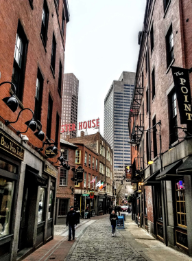 This image shows the historic Freedom Trail in Boston, a 2.5-mile path that connects iconic landmarks like Faneuil Hall and the Paul Revere House. The trail is paved with red bricks and weaves through vibrant city streets, offering visitors a glimpse into America’s revolutionary history while surrounded by modern Boston architecture.