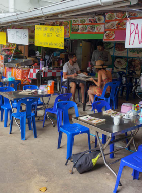 This image shows beachside street food stalls on Phi Phi Island. It highlights fresh coconut water, spicy curries, and tropical snacks enjoyed by visitors by the ocean waves.