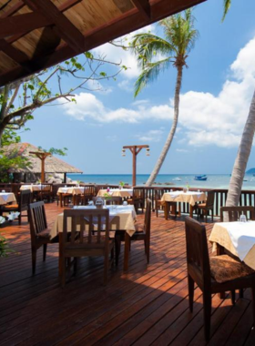 This image shows Sensi Paradise Beach Resort’s charming wooden bungalows surrounded by lush tropical gardens, with stunning views of Ao Leuk Bay. Guests can enjoy private beach access, relaxing spa services, and various water activities like snorkeling.