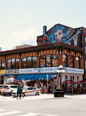 This image shows ByWard Market in the heart of Ottawa, a vibrant, bustling area full of local vendors selling fresh produce, unique arts and crafts, and delicious foods. The historic market is a lively place where tourists and locals come together to experience the rich culture and culinary delights of Ottawa. The streets are lined with charming cafes, restaurants, and boutiques, offering visitors a mix of shopping and dining in a fun, lively atmosphere perfect for exploring.