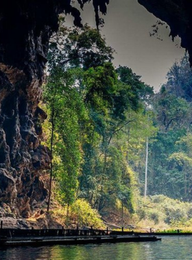 This image shows Lod Cave’s interior, accessible by bamboo raft. Stalactites and stalagmites create an awe-inspiring view as visitors explore the cave’s mystical beauty with guides illuminating the formations.