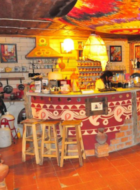 This image shows a steaming cup of chai served at Art in Chai, with a colorful interior featuring local art. The cafe's cozy ambiance and cultural vibe make it a favorite spot for live music and creative gatherings in Pai.