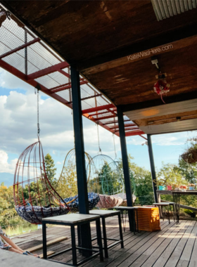 This image shows the serene countryside view from Romance Cafe in Pai, with a cup of espresso and a slice of homemade cake on the table. The peaceful vibe and natural surroundings make it a perfect escape from the town’s hustle.