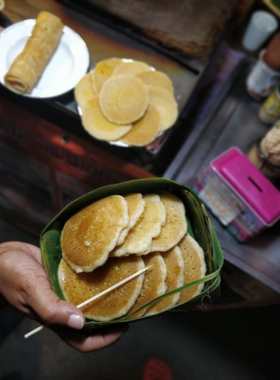 This image shows a fluffy pancake topped with bananas, Nutella, and syrup at Grandma’s Pancakes in Pai. The casual street food stall offers quick, delicious treats that are perfect for a sweet snack or dessert.