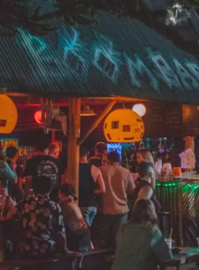 This image shows Paradise Bar in Pai, Thailand, a buzzing nightclub with neon décor, a spacious dance floor, and electrifying DJ performances. The venue offers expertly crafted drinks and a high-energy atmosphere, making it the ultimate destination for party enthusiasts.