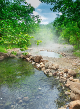 This image shows hidden hot springs surrounded by greenery in Pai, Thailand, offering a serene and relaxing spot for visitors to soak in the warm waters and enjoy nature.