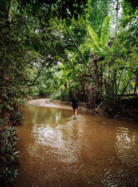 This image shows the picturesque Mae Yen Waterfall, tucked in the forest of Pai, Thailand, cascading into a clear pool after a scenic trek through lush landscapes.