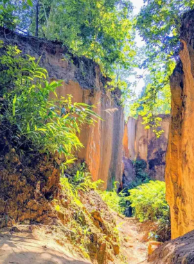 This image shows the unique Land Split in Pai, Thailand, a geological phenomenon surrounded by greenery and a small farm, offering a peaceful and educational visit.