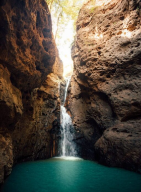 This image shows the secluded Pam Bok Waterfall in Pai, Thailand, with its cascading waters nestled between rocky cliffs, creating a peaceful and shaded retreat.