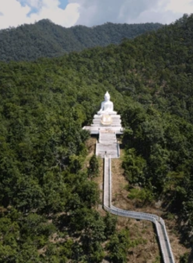 This image shows the majestic White Buddha on the hill in Pai, Thailand, overlooking lush green valleys and mountains. The serene setting captures the essence of peace and spirituality. Perfect for those who love scenic and meditative landscapes.