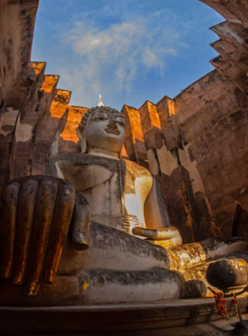 This image shows the towering seated Buddha statue at Wat Si Chum, surrounded by a serene and peaceful environment. The massive statue, visible through a narrow opening, offers visitors a tranquil and awe-inspiring experience while reflecting the spiritual legacy of the Sukhothai period.