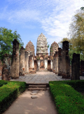 This image shows the impressive Wat Sri Sawai temple, showcasing its three towering prangs (spires). The temple reflects the blend of Hindu and Buddhist influences, offering visitors a fascinating glimpse into the cultural evolution of the region amidst lush greenery.