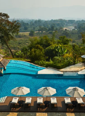 This image shows Le Méridien Chiang Rai Resort, with its stunning riverside location, modern architecture, and inviting outdoor pool area. The image captures the resort’s tranquil ambiance, ideal for guests seeking comfort and luxury in Chiang Rai.