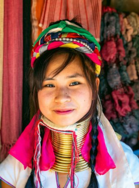 Long-Neck-Hill-Tribe-Village-Chiang-Rai This image shows a woman from the Long Neck Hill Tribe in Chiang Rai, wearing brass rings around her neck. Visitors can experience the unique traditions of the Karen people, learning about their culture and lifestyle in this fascinating village.
