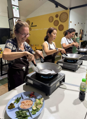 Suwannee-Thai-Cooking-Class-Chiang-Rai This image shows participants learning to cook traditional Thai dishes at Suwannee Thai Cooking Class in Chiang Rai. The hands-on class includes a market tour and the chance to prepare authentic Thai meals, offering a fun and interactive cultural experience.
