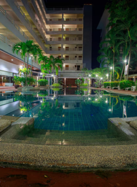 This image shows the serene poolside area of Hat Yai Paradise Hotel, with crystal-clear water surrounded by lush greenery and comfortable lounging chairs. The calm atmosphere reflects the hotel’s tranquil environment, perfect for guests looking to relax and unwind during their stay in Hat Yai.