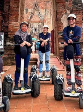 This image shows a fun Segway tour through the ancient temples and ruins of Ayutthaya. Visitors glide smoothly past historical landmarks, temples, and lush green gardens while learning about the city’s rich history and culture. The eco-friendly Segway offers a comfortable and easy ride, making it a perfect way for tourists of all ages to explore Ayutthaya while enjoying the peaceful surroundings and magnificent views of UNESCO-listed sites.