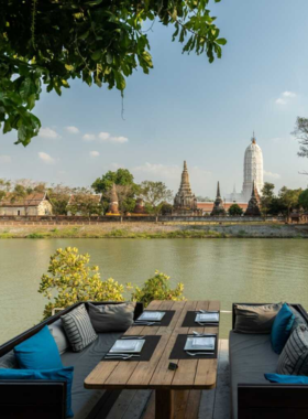 This image shows Sala Ayutthaya Eatery And Bar, a fine dining restaurant with elegant decor overlooking the Chao Phraya River. It captures the serene ambiance and scenic views that complement dishes like tom yum river prawn soup. The riverside setting and stylish interiors make it an ideal spot for romantic dinners or special occasions.